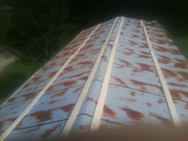 Rusted metal roof panels with new wood purlins before replacement — Storm Damage Roof Repair in Sheldon by Roofing Brothers