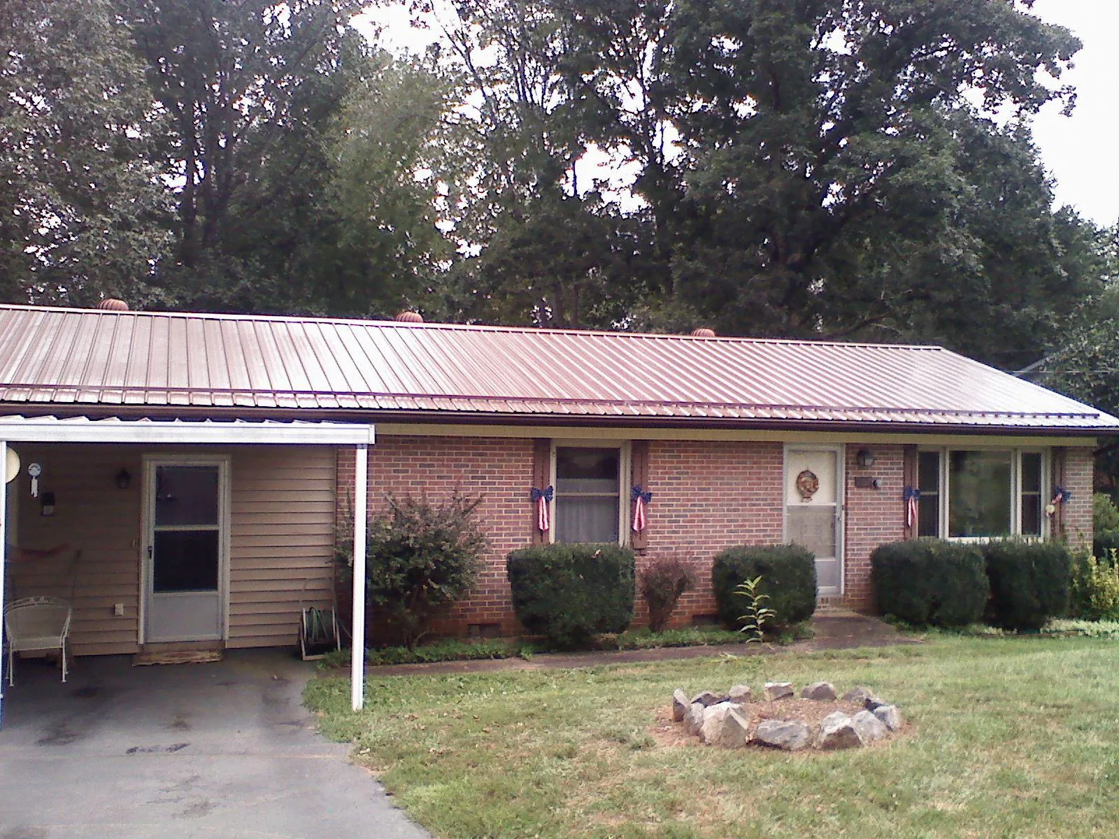 Bronze metal roof and carport on a brick ranch home — Roof Repair work by our crew in Sheldon